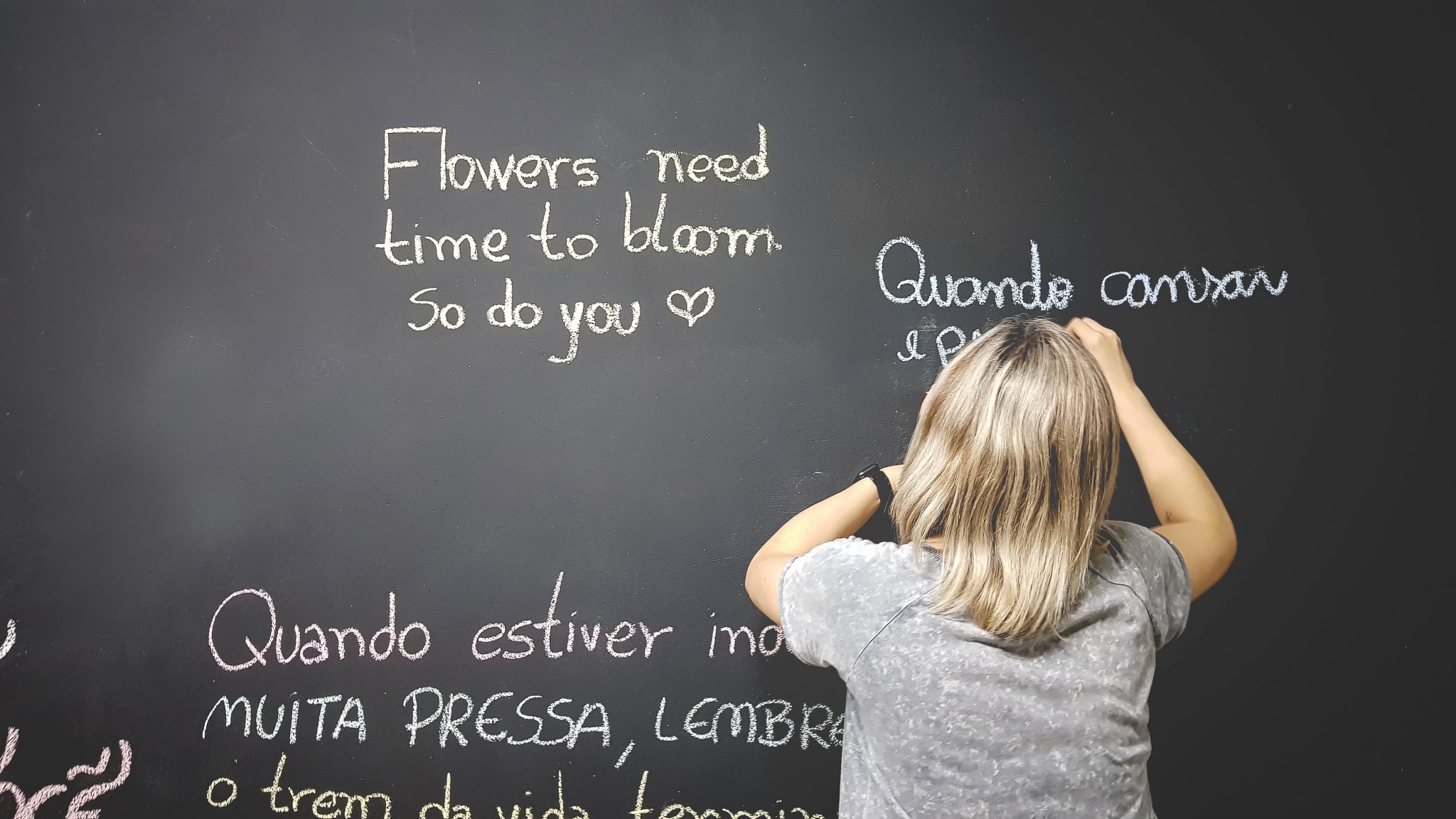 一个女人在黑板上用西班牙语写字