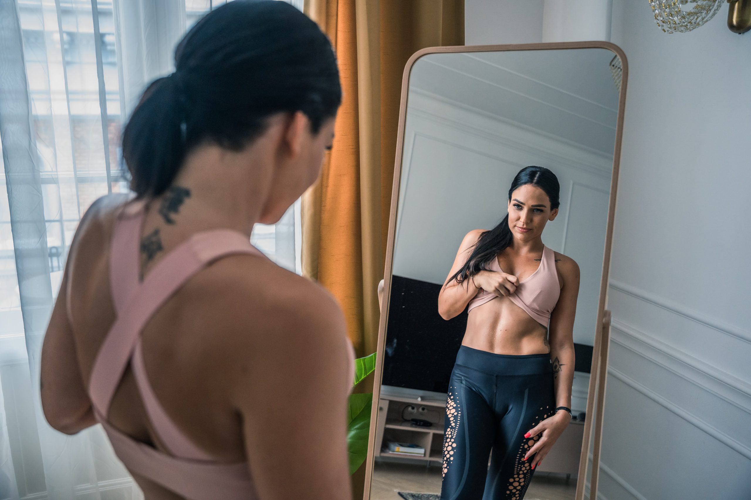 一个女人看着镜子里的腹肌