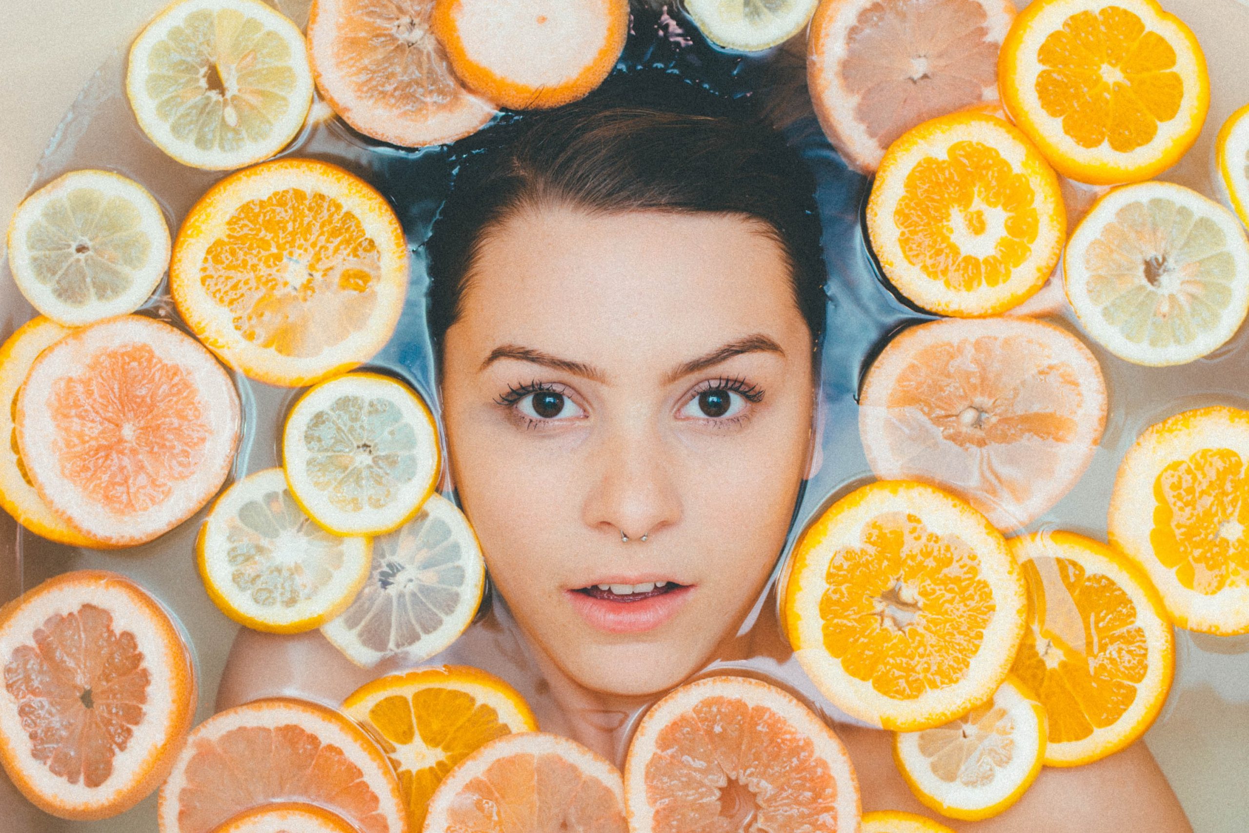 水中女子被柑橘类水果包围
