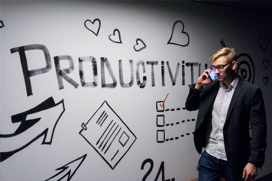 一名男子在写着“生产力”的墙上打电话