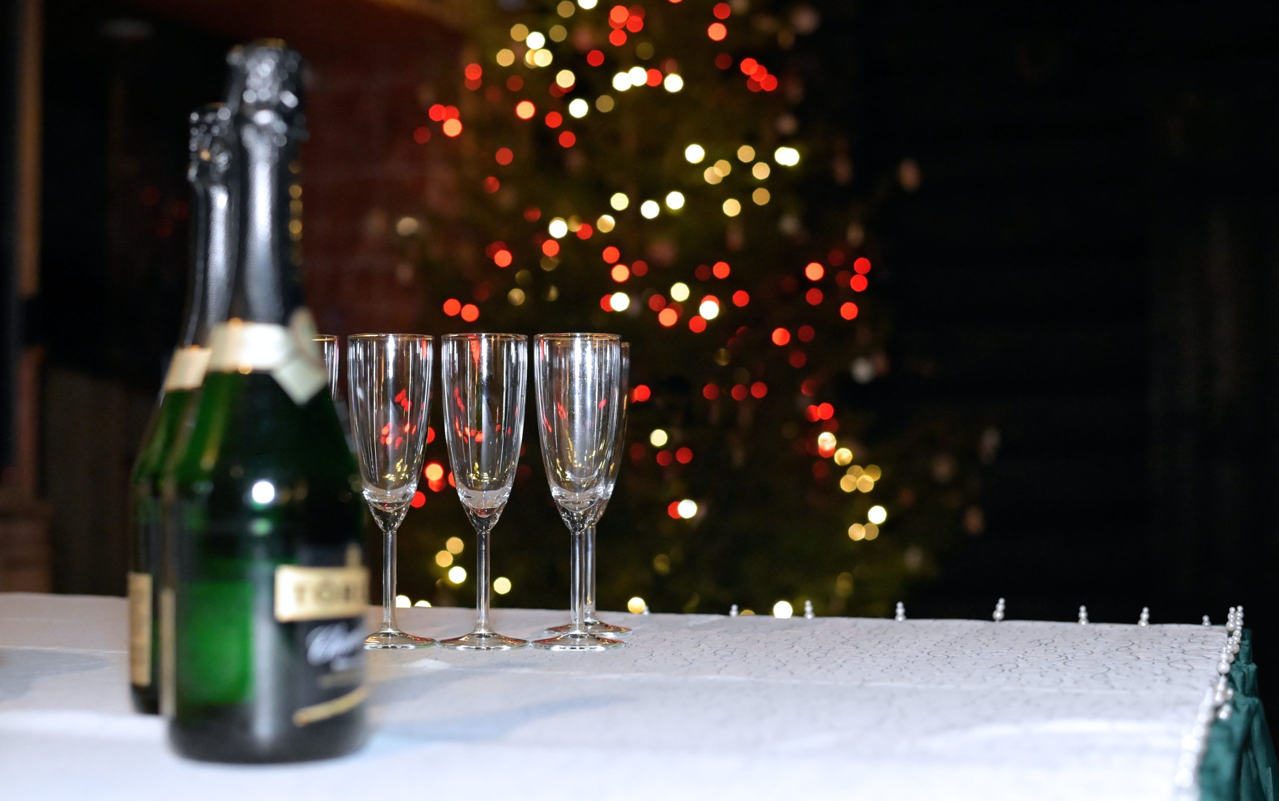 香槟酒和玻璃杯放在圣诞树前